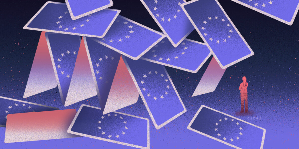 A woman stands trapped in a collapsing house of cards, each card is decorated with the EU symbol.